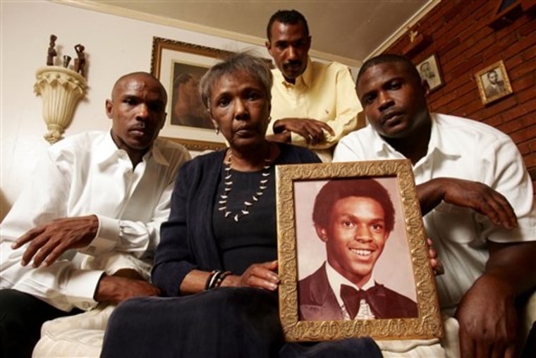 Ruby Session, center, holds a photo of her son Tim Cole, who died in prison, as her sons' Rodney Kennard, Cory Session and Reginald Kennard, from left, pose for the camera, in Forth Worth, Texas, in June 2008.